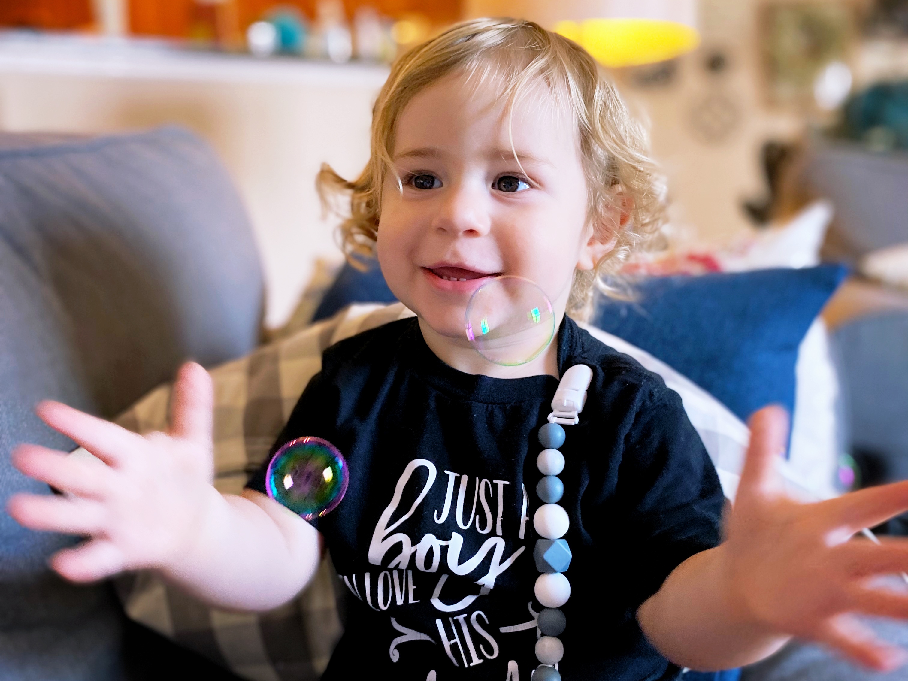 photo of child playing with bubbles
