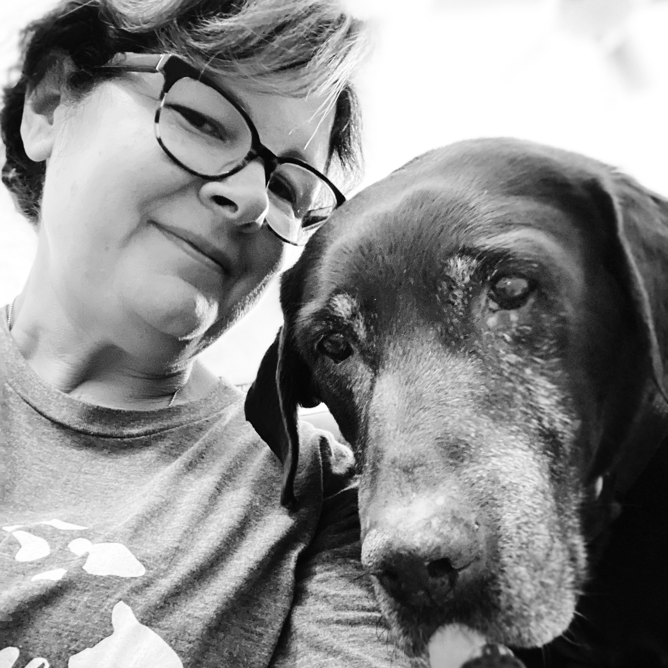 Picture of author (Connie) with her previous dog, a Labrador, looking into the camera, taking a selfie. 