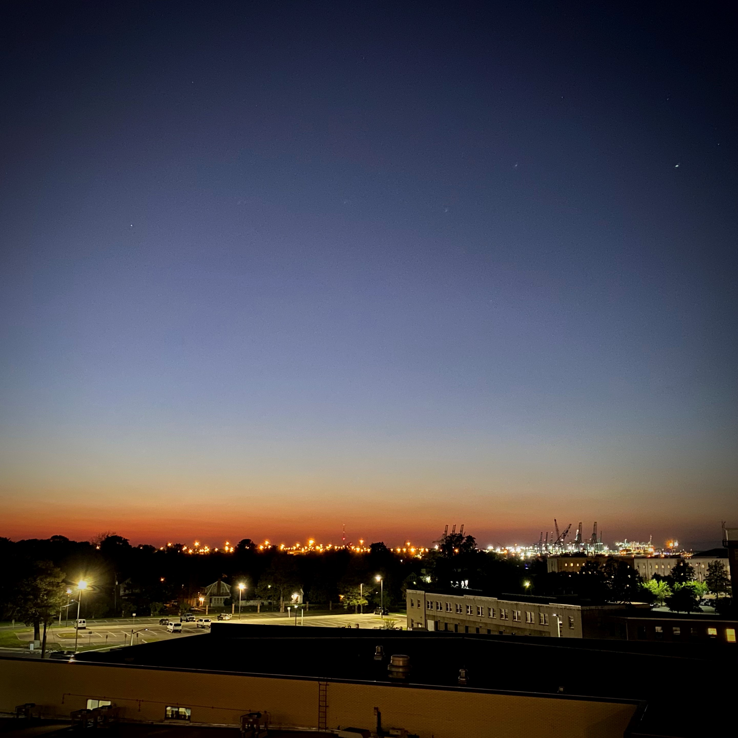 Photo of sunset over the lights of a city
